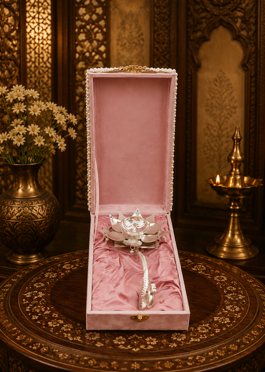 Decorative item in a pink box on a ornate table with floral and candle background