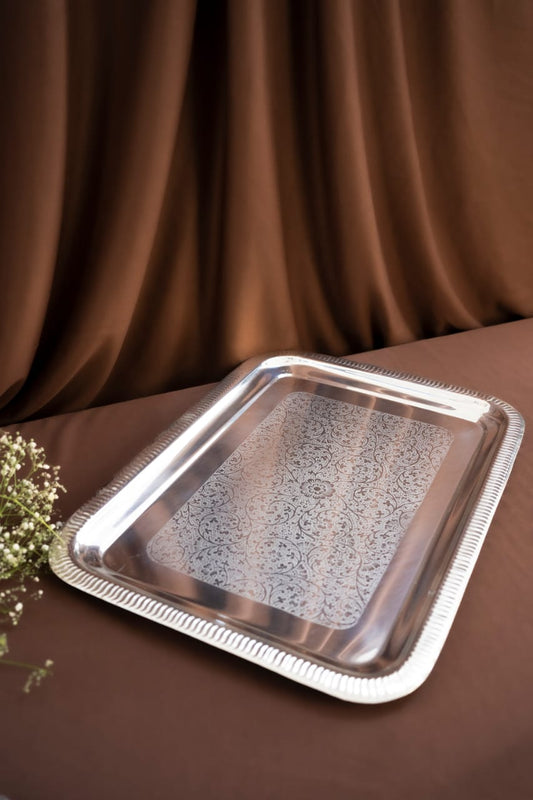 Silver decorative tray on a brown fabric background