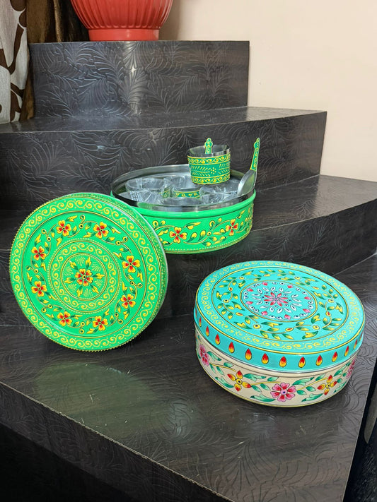 Decorative boxes with floral patterns on a dark surface