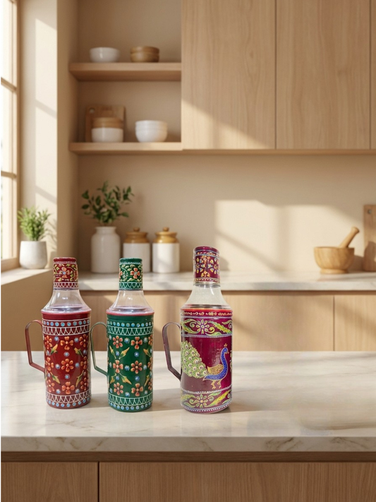 Three decorative bottles on a kitchen counter with wooden cabinets and shelves in the background.