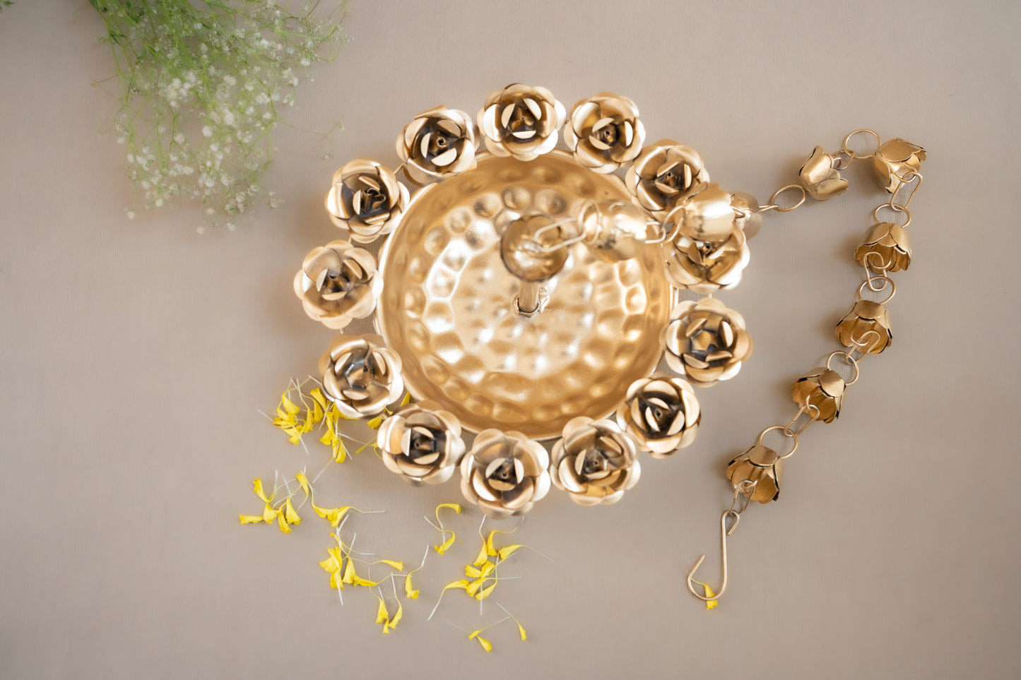 Decorative gold wall clock with floral design on a neutral background