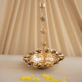 Gold decorative hanging item with yellow petals on a beige background