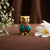 Decorative owl figurine with gemstones on a brown surface with flowers.