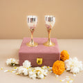Two gold and silver goblets on a pink box with flowers on a beige background