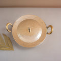 Gold decorative plate with handles on a light gray background