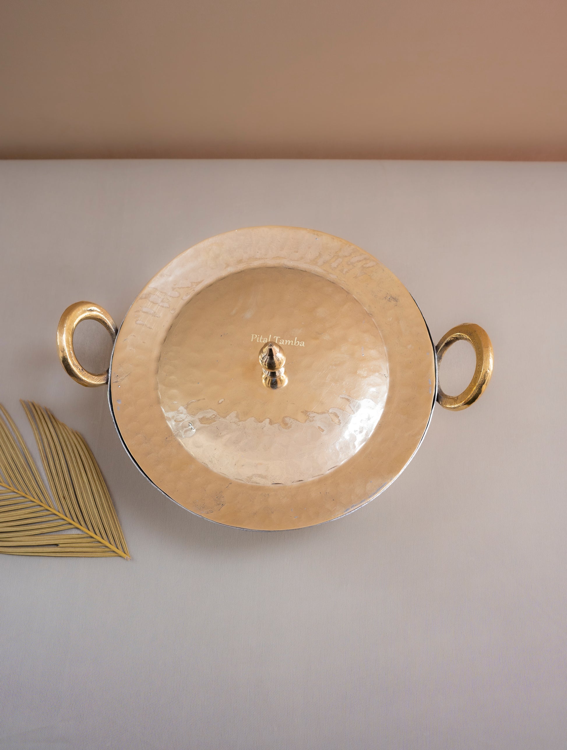 Gold decorative plate with handles on a light gray background