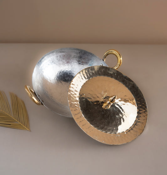 Two metallic pendants, one gold and one silver, on a neutral background.