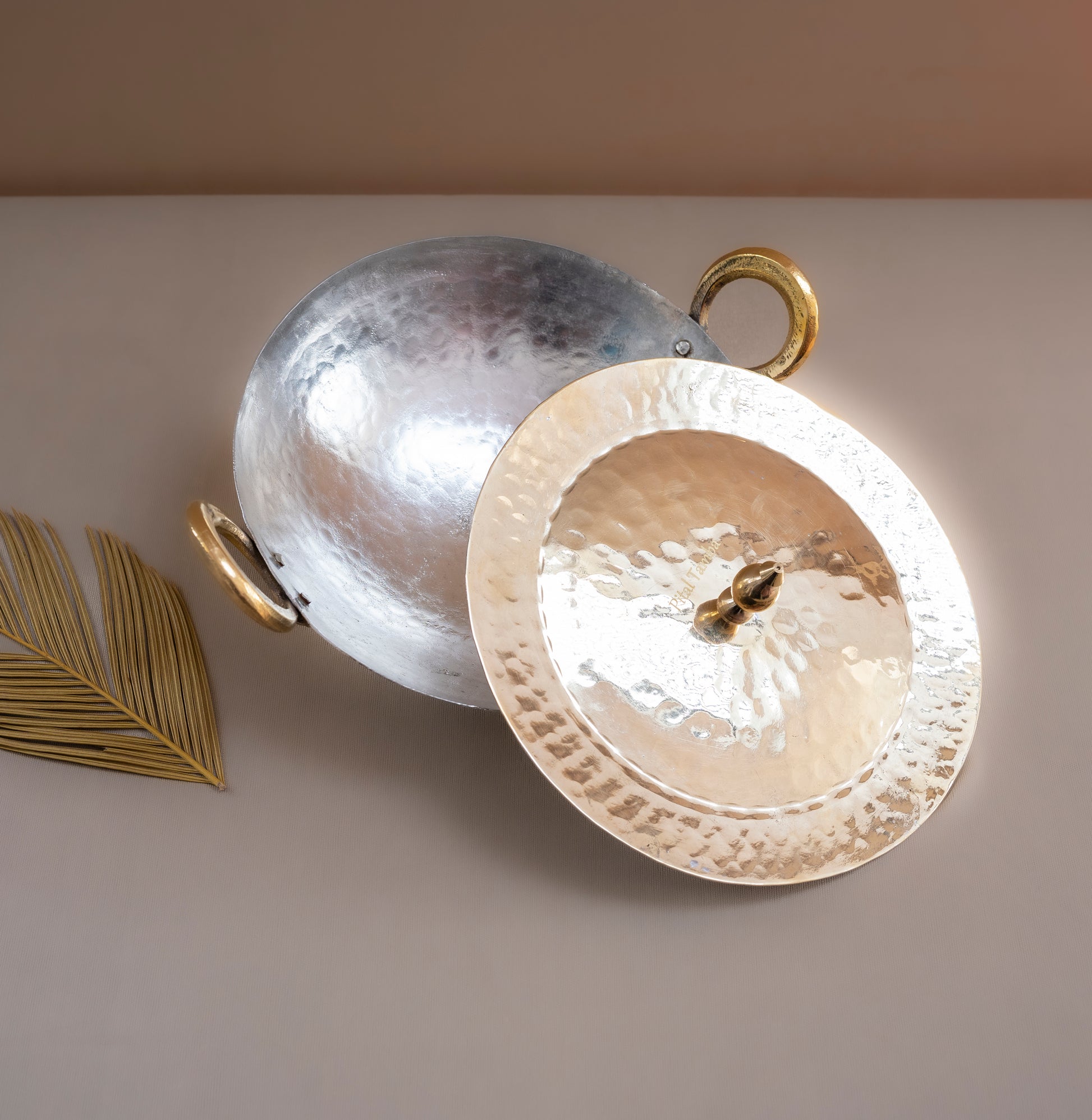 Two metallic plates, one silver and one gold, on a light surface with a beige background.