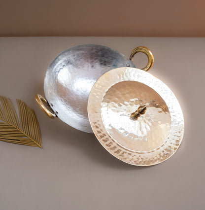 Two metallic plates, one silver and one gold, on a light surface with a beige background.