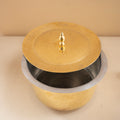 Brass pot with a lid on a beige background