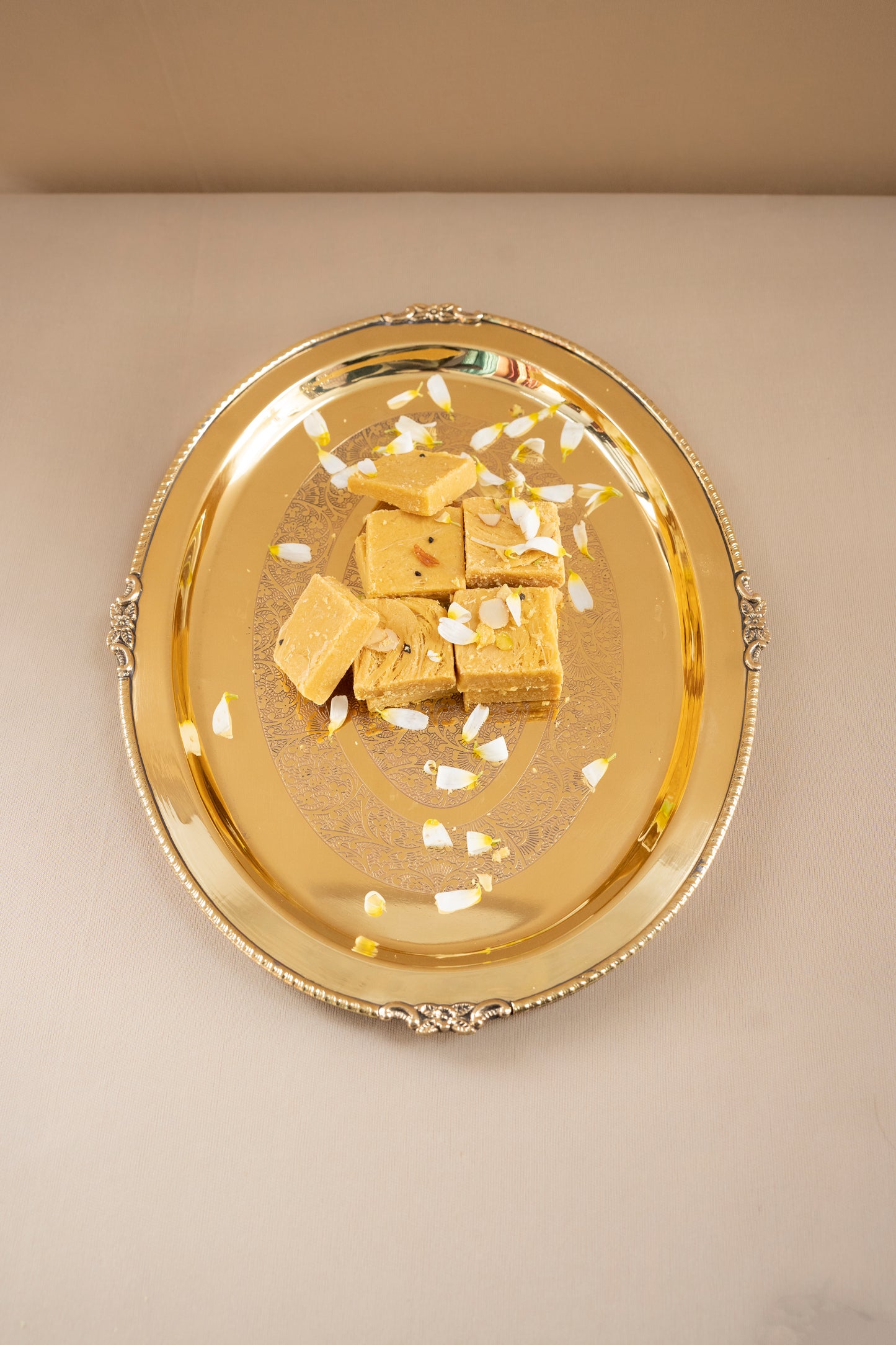 Gold tray with gold cubes on a beige background