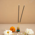 Incense sticks in a holder with flowers on a beige background