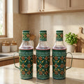 Three decorative glass bottles with floral patterns on a kitchen counter.
