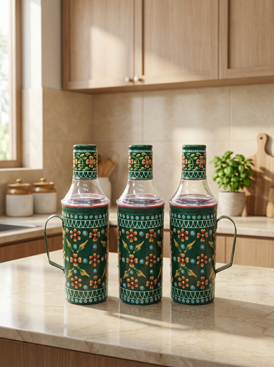 Three decorative glass bottles with floral patterns on a kitchen counter.