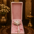 Decorative item in a pink box on a ornate table with floral and candle background