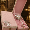 Pink jewelry box with silver jewelry on a decorative surface