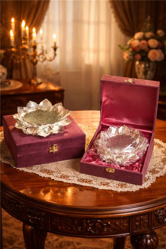 Two silver bowls in open purple boxes on a wooden table with a decorative background.