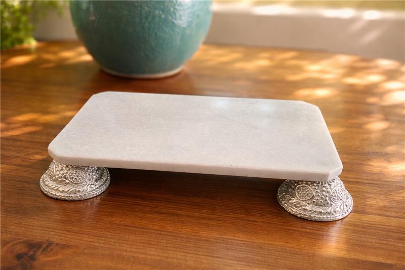 Decorative stone platform with silver bases on a wooden surface