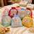Decorative bags with elephant designs on a bed with gift boxes in the background
