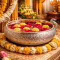 Decorative bowl with flowers on a ornate table, surrounded by floral arrangements and candles.