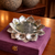 Silver lotus-shaped dish on a purple box with blurred background