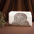 Decorative white towel with an ornate brown emblem on a brown background