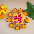 Decorative arrangement of marigold flowers and a small cake on a light background
