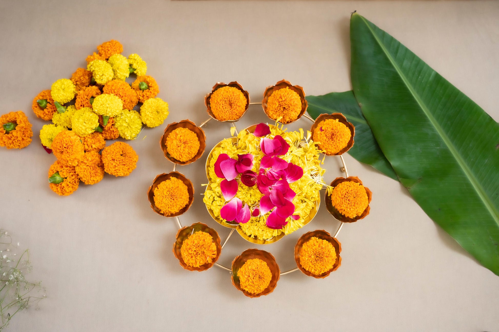 Decorative arrangement of marigold flowers and a small cake on a light background