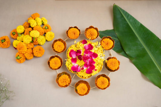 Decorative arrangement of marigold flowers and a small cake on a light background