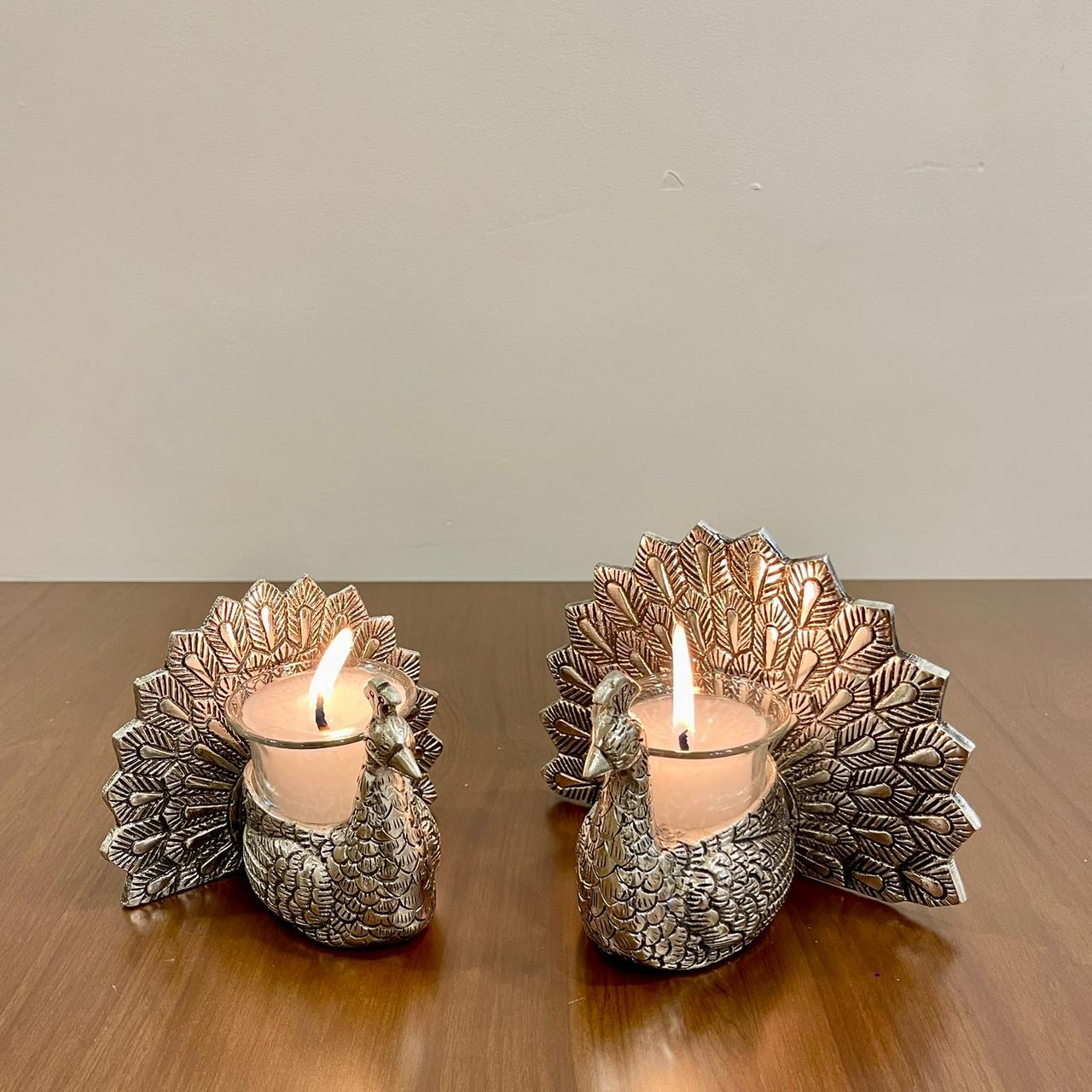 Two silver peacock-shaped candle holders