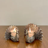Two silver peacock-shaped candle holders