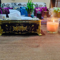 Decorative tissue box with a lit candle on a table