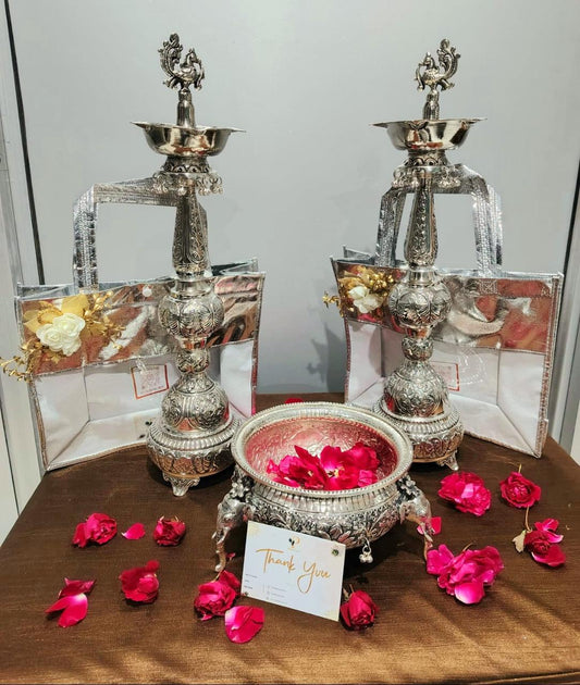 Decorative silver lamps with rose petals and a card on a brown surface.