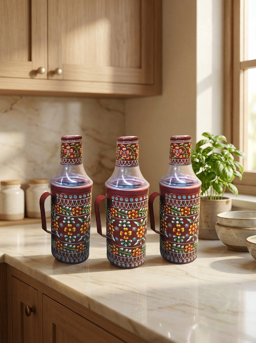 Three colorful ceramic bottles with handles on a kitchen counter.