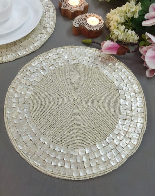 Round woven placemat on a gray surface with decorative elements.