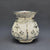 Decorative silver vase with floral patterns on a gray background