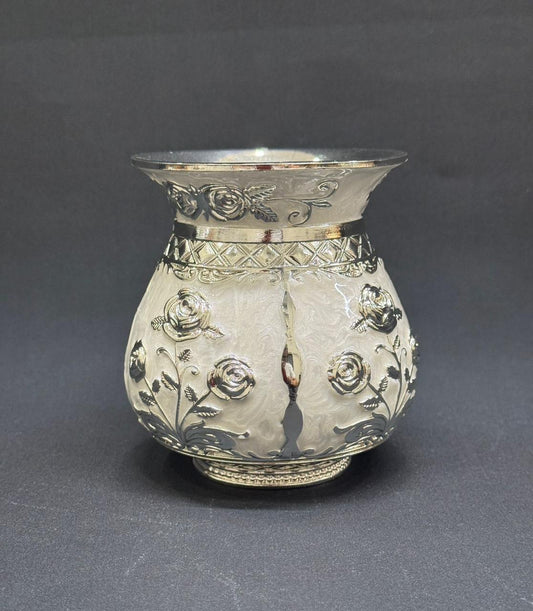 Decorative silver vase with floral patterns on a gray background