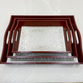 Two decorative trays with wooden frames on a white marble surface