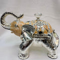 Decorative elephant figurine with silver and gold accents on a white background