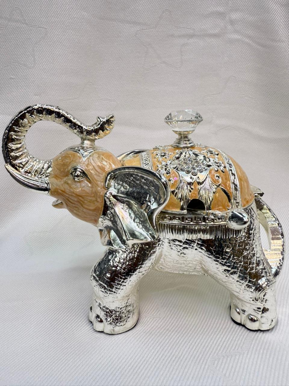 Decorative elephant figurine with silver and gold accents on a white background
