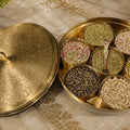 Decorative brass container with lid on a marble surface