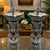 Decorative silver candle holders on a reflective surface with a blurred background