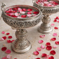 Decorative silver bowls with rose petals on a marble surface