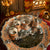 Decorative silver tray with cups and a bowl on a wooden surface.