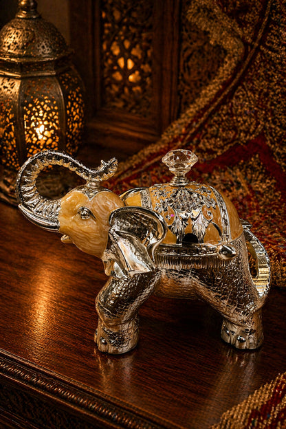 Decorative silver and gold elephant figurine on a wooden surface with warm lighting.