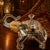 Decorative silver and gold elephant figurine on a wooden surface with warm lighting.