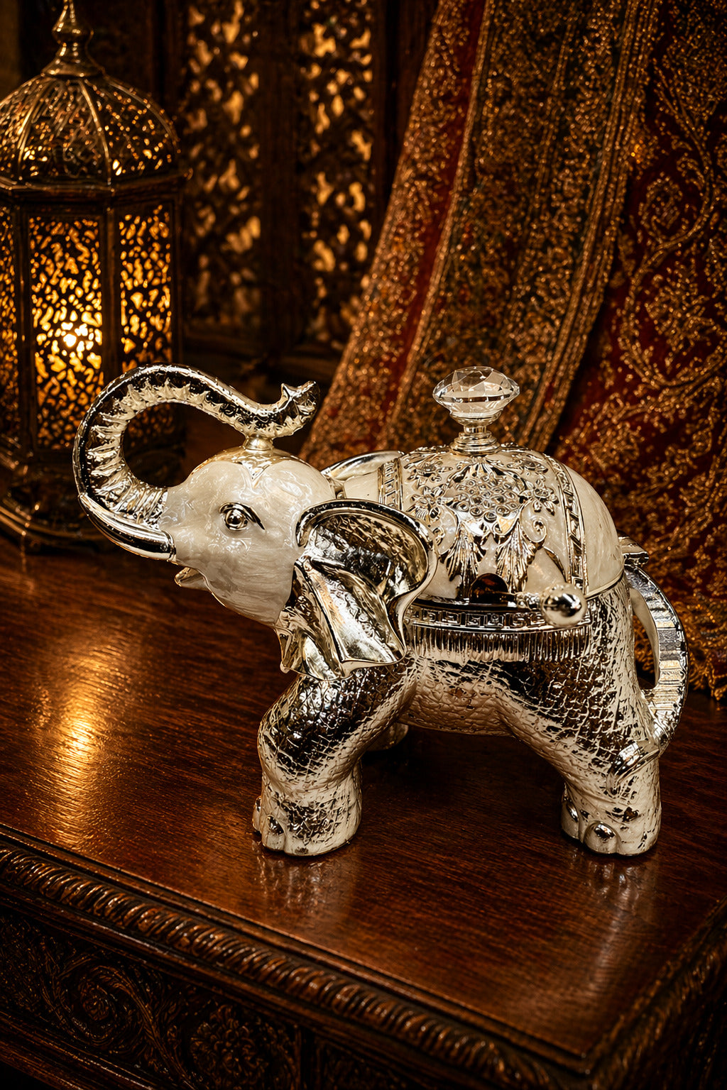 Decorative silver elephant with a glass container on a wooden surface