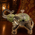 Decorative elephant with crystal ball on a wooden surface