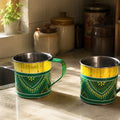 Two green and yellow patterned mugs on a kitchen counter.