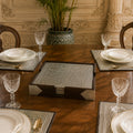 Dining table set with plates, glasses, and silverware in a formal setting.